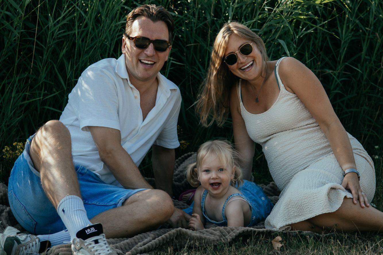 Een gezin lacht samen in het gras